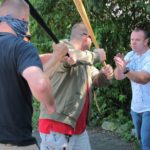 Author moving to the outside of a group of attackers to "stack them up".  Fighting one person at a time is better than fighting all three at once