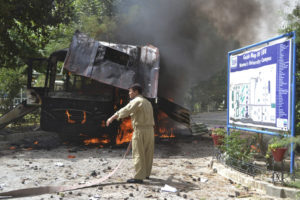 A firefighter stands near a burning bus after a bomb attack in Quetta
