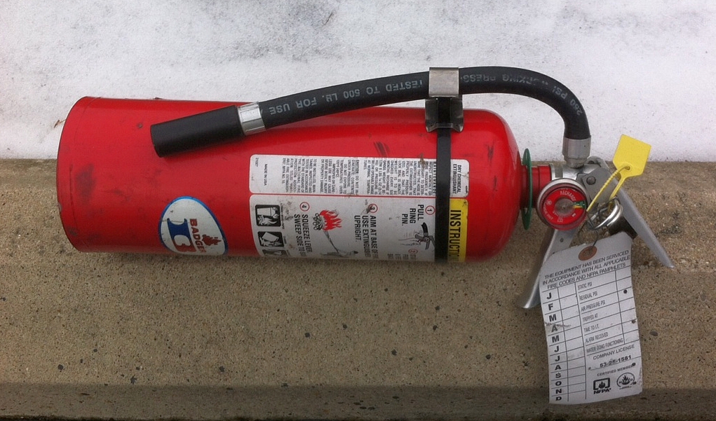 Keep the hose attached to the body just like this. Spray and then thrust with the bottom of the extinguisher's body.