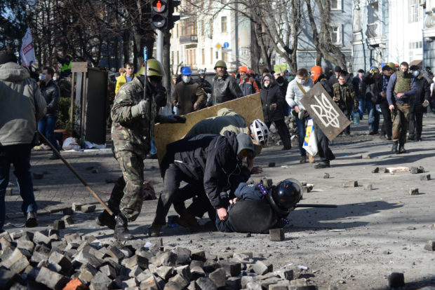 A police officer attacked by protesters during clashes in Ukraine.