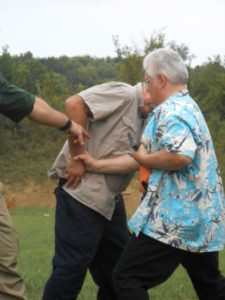 Adjusting student's body position to avoid shooting his own arm in the struggle