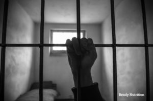 hand of a prisoner grabbed the bars of the prison