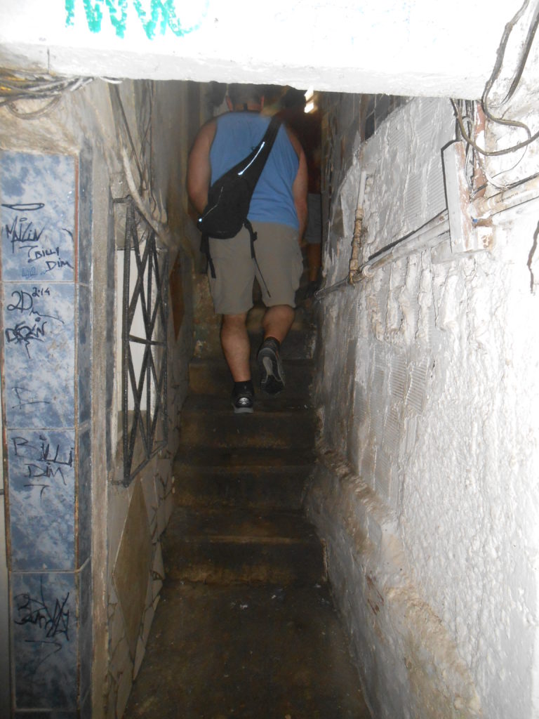 Walking on a sidewalk between favela houses. Most favelas have no roads and residents walk in narrow passageways like this to get to their "house."