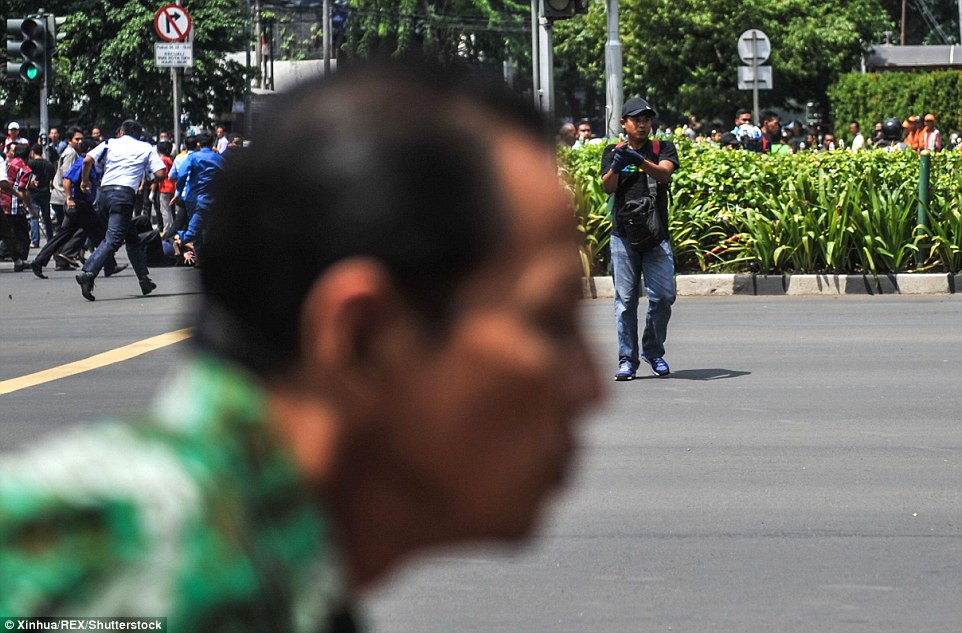 3027535E00000578-3398712-A_civilian_races_past_the_camera_as_hundreds_of_people_in_Jakart-m-23_1452755535141