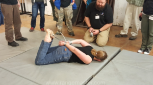 Caleb Causey from Lone Star medics coaching Julie Thomas through the friction cutting process in case your hands are zip tied behind the back. Photo from Tiffany Johnson.