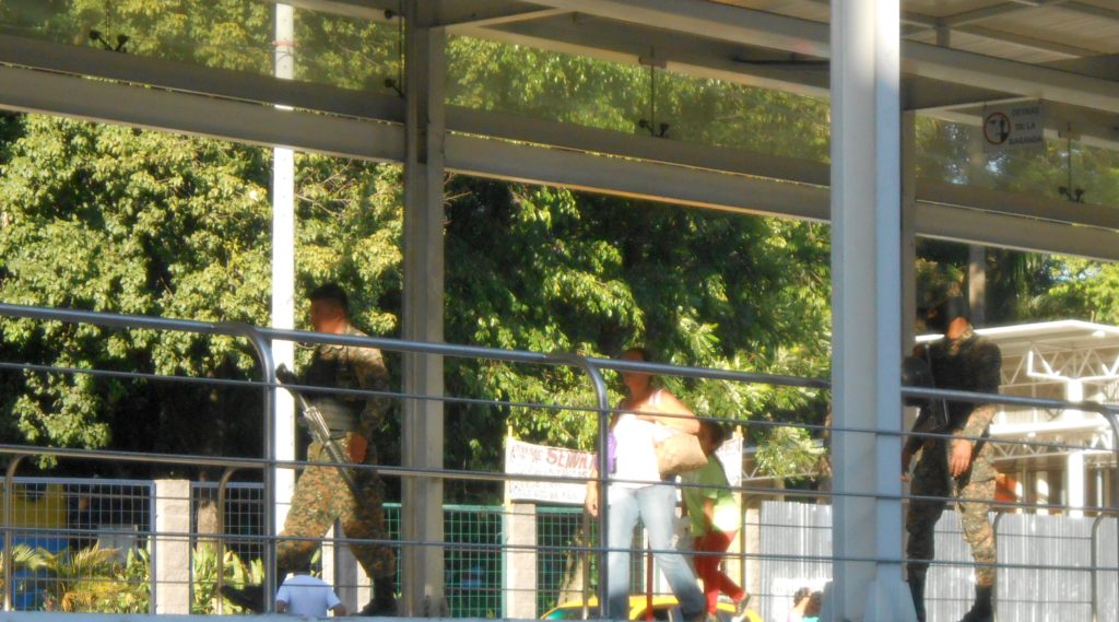 Soldiers patrolling a San Salvador bus stop,